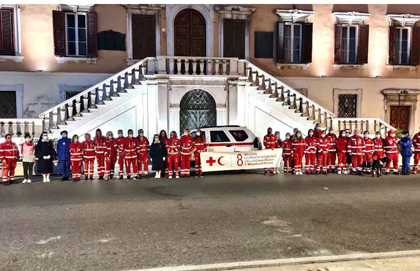 alcuni volontari della Croce Rossa schierati sotto il Palazzo Civico