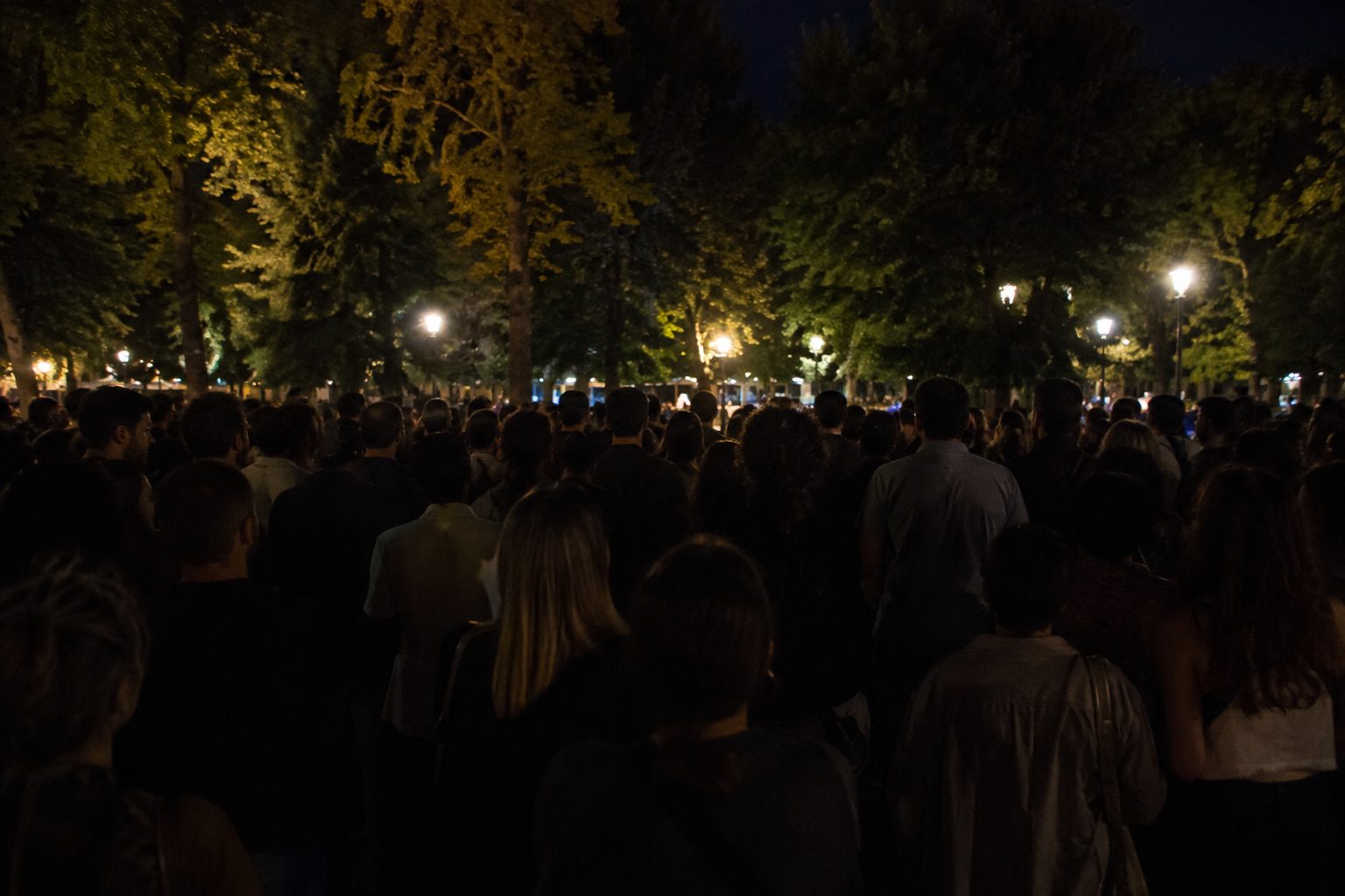 Persone che assistono a un concerto o spettacolo all'aperto in una piazza di Livorno