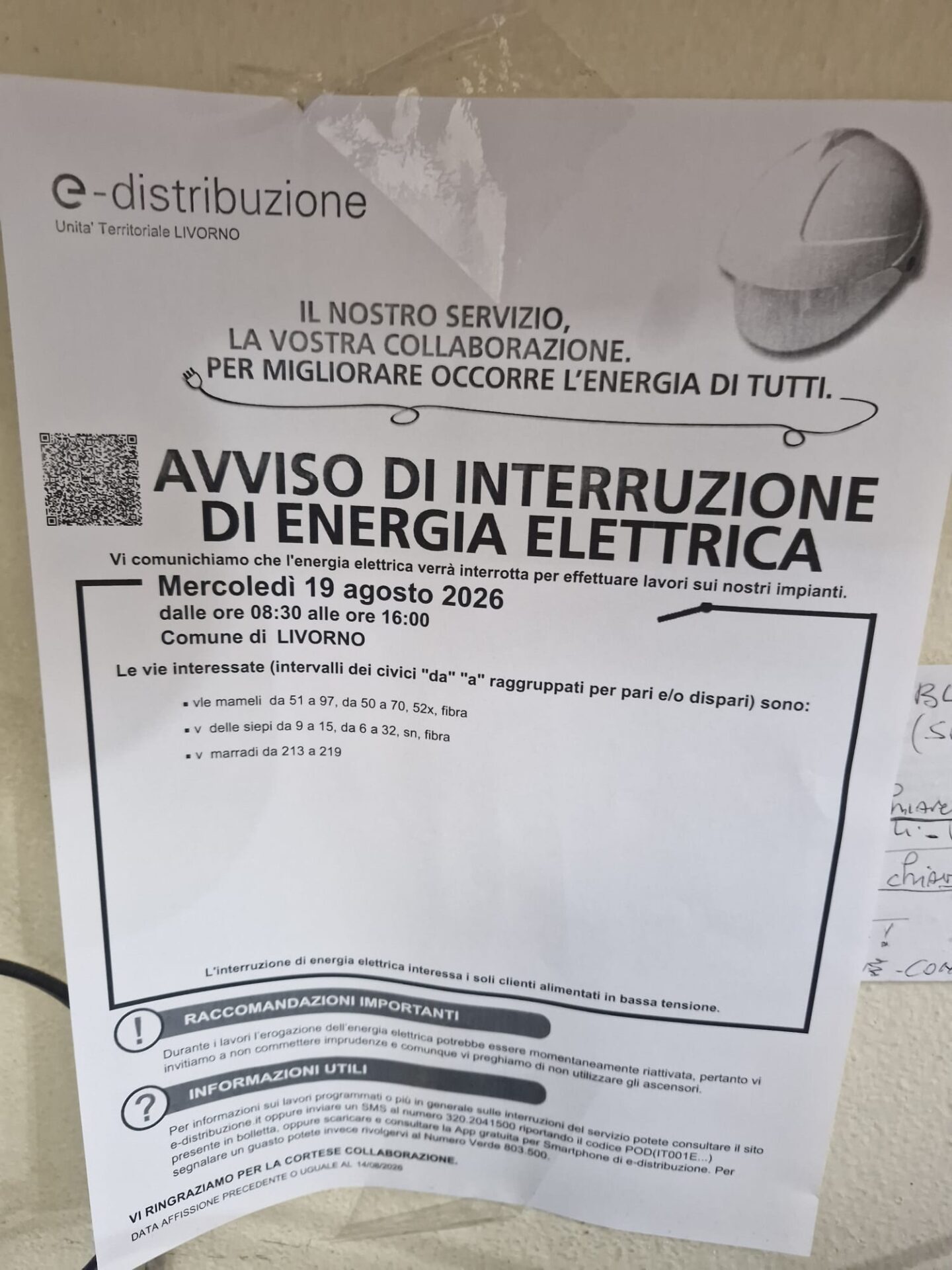 Un avviso di interruzione di corrente di E-Distribuzione affisso su un portone a Livorno
