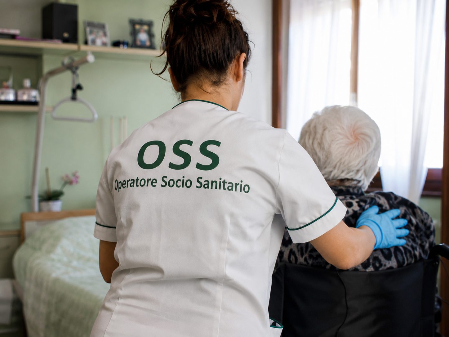 Operatore socio sanitario assiste un paziente anziano in una struttura sanitaria.