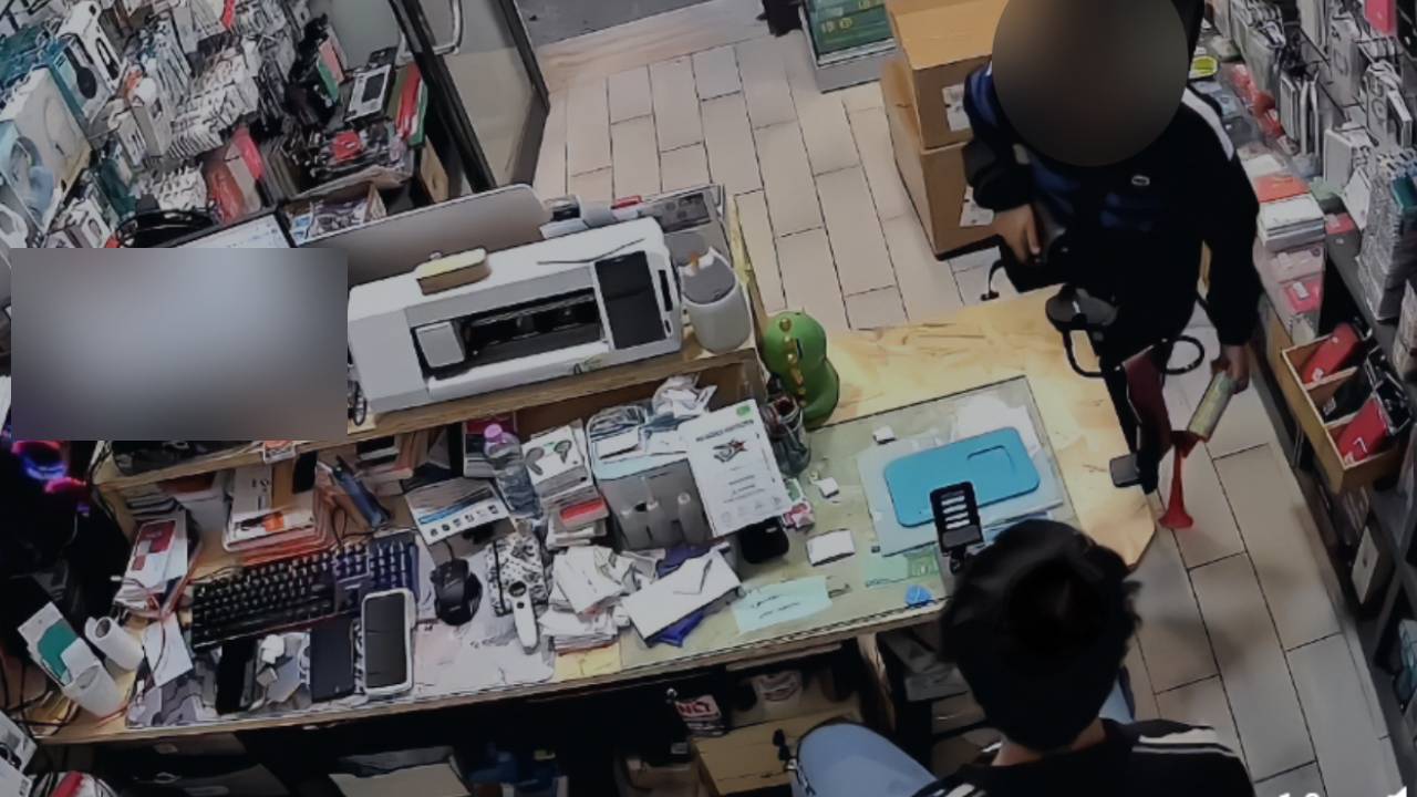 Ragazzino con trombetta in un negozio, simulando una rapina